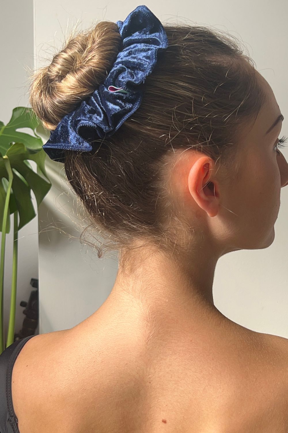 ballerina wearing crushed velvet hair scrunchie in navy blue colour.