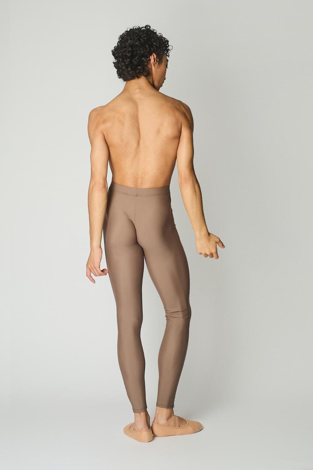 male ballet dancer seen from the back, wearing sustainably made brown dance tights and bare chest against a while wall