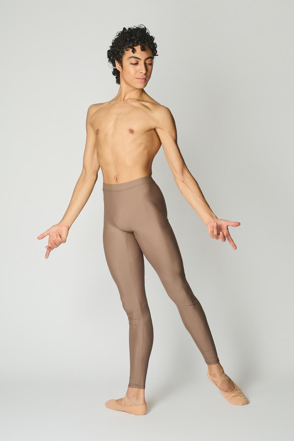 male ballet dancer wearing sustainably made brown dance tights and bare chest against a while wall