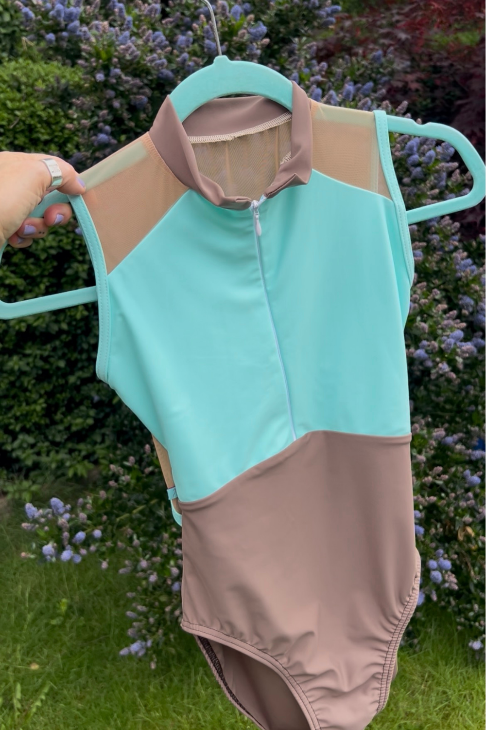 a zip front ballet leotard shown on a hanger