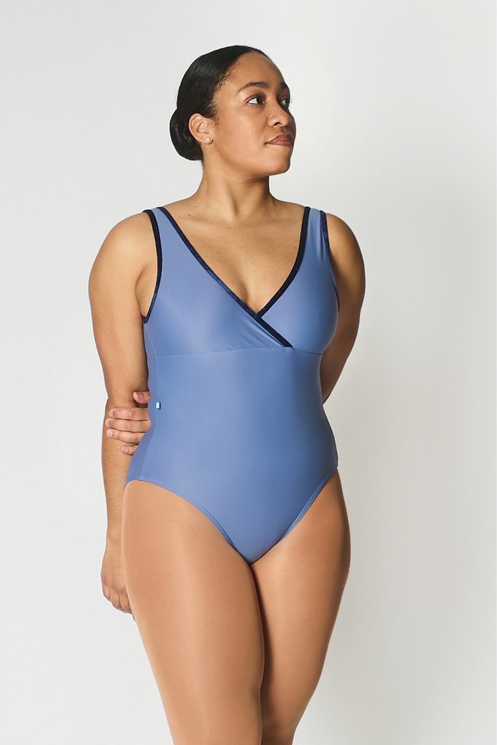 Woman wearing a blue leotard against a white background
