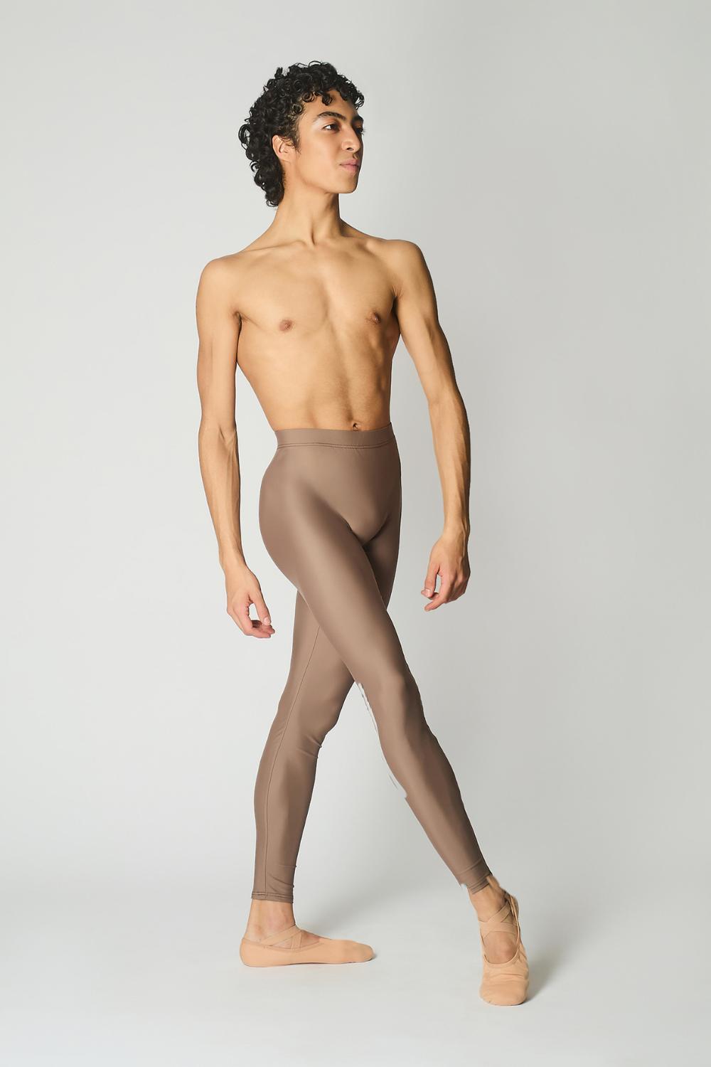 male ballet dancer wearing sustainably made brown dance tights and bare chest against a while wall 
