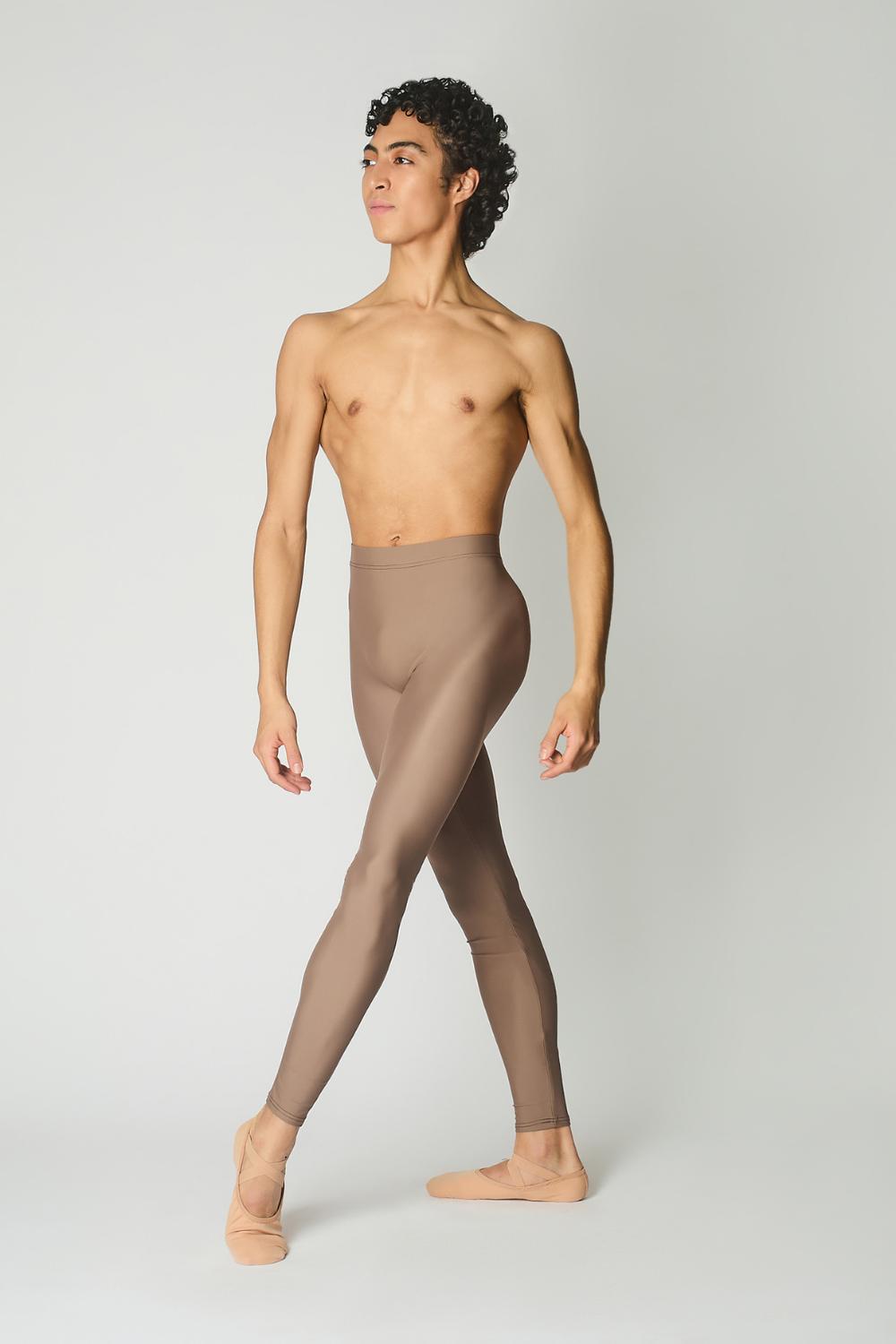 male ballet dancer wearing sustainably made brown dance tights and bare chest against a while wall 
