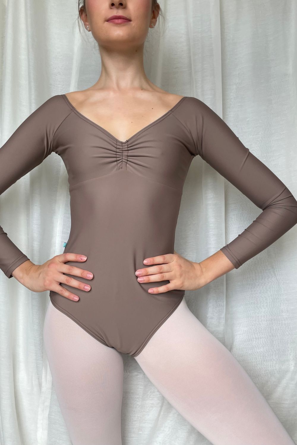 ballerina wearing a long sleeve leotard with v-neck in light brown