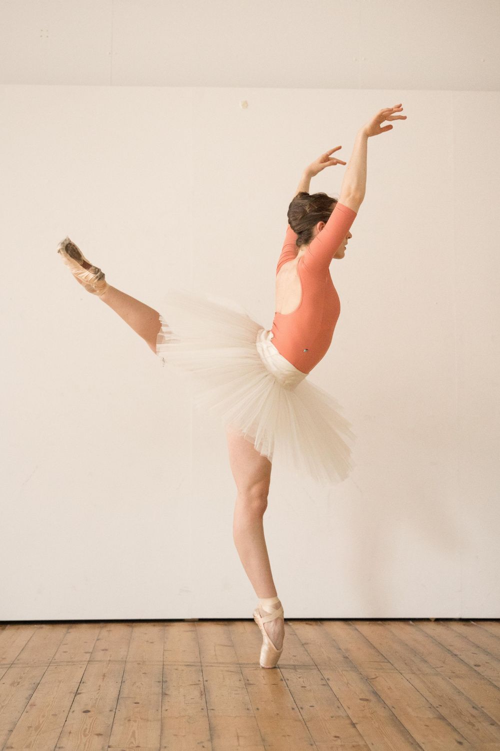 ballerina in a white tutu with imperfect pointes barcelona leotard in porcelain peach